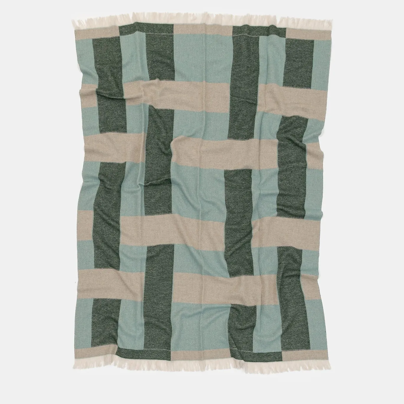 Coperta verde con frange e motivi intrecciati