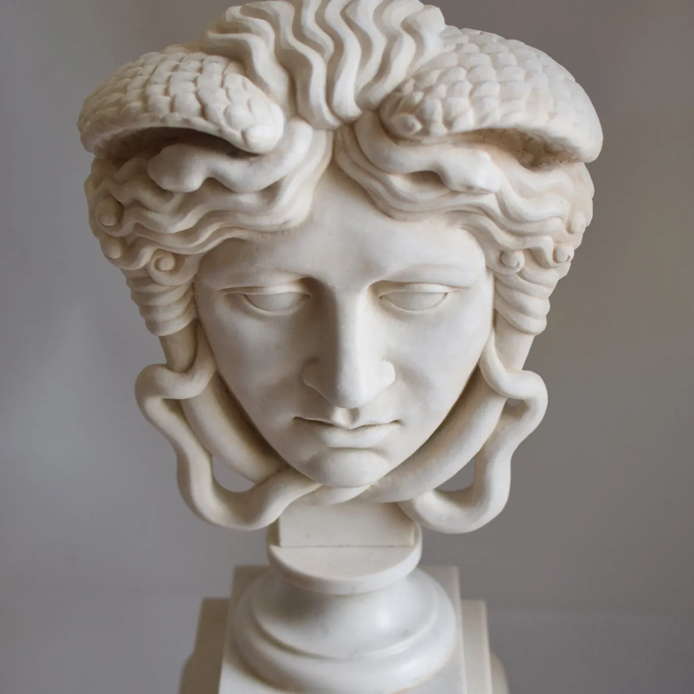 Scultura Medusa in marmo bianco di Carrara su trapezoforo