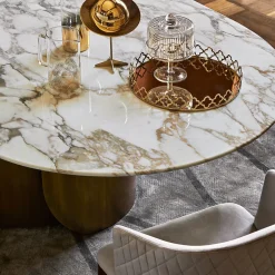 Tavolo da pranzo Oscar con base ovale in bronzo e top in marmo Calacatta Oro