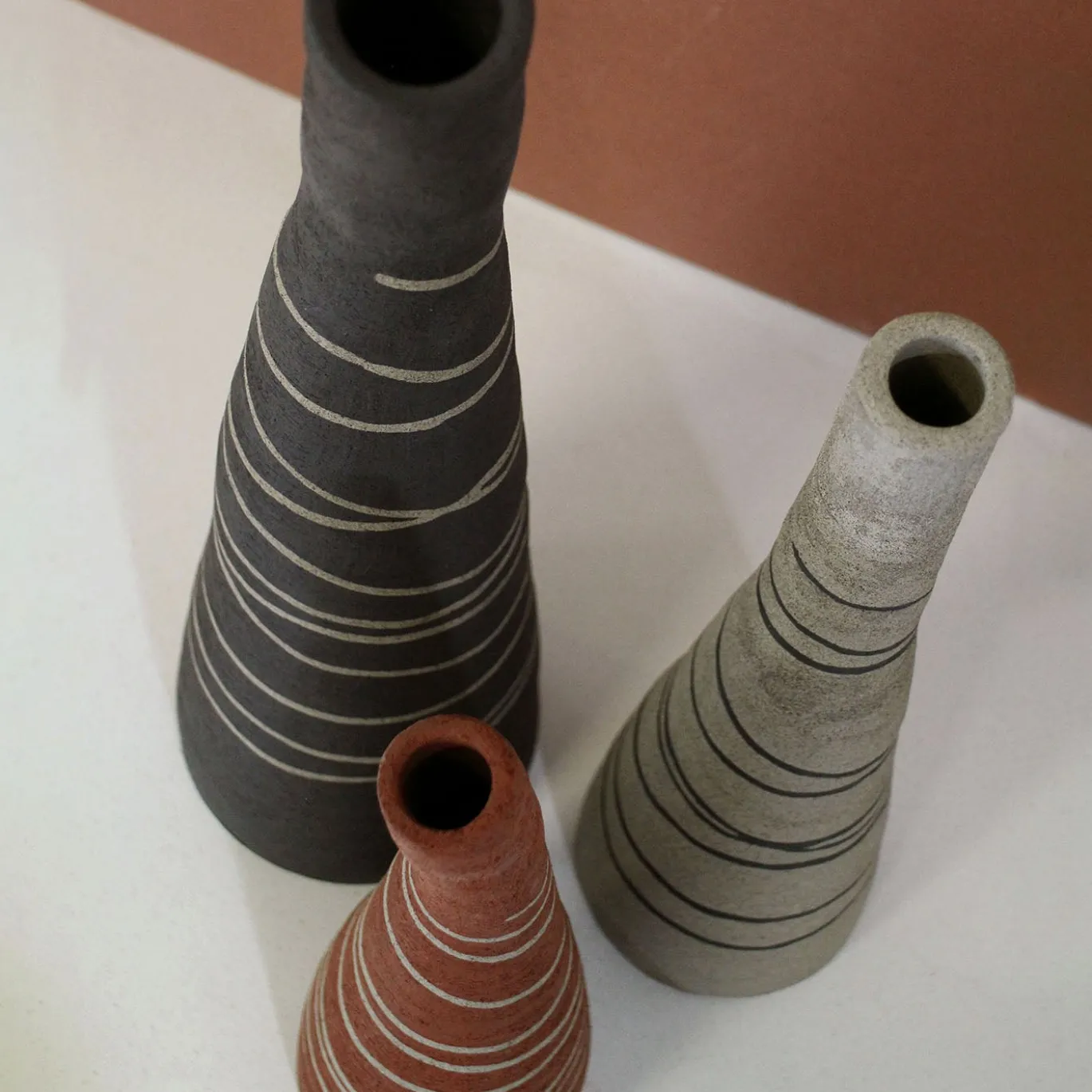 Vaso in gres grigio sabbia testurizzato a forma di bottiglia tronca con intarsi
